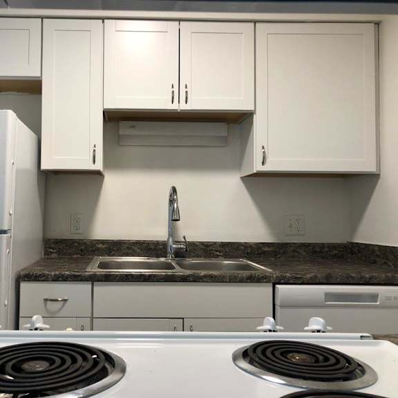 a kitchen with a stove top oven next to a refrigerator