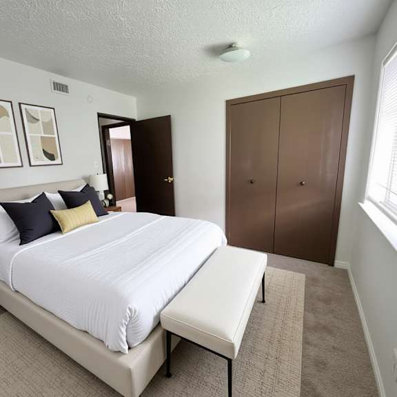 a bedroom with a large bed and a nightstand with a lamp.