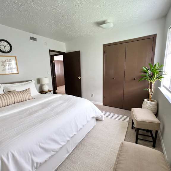 a bedroom with a large bed and a brown wardrobe.
