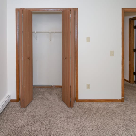 an empty bedroom with a closet and a door to a bathroom