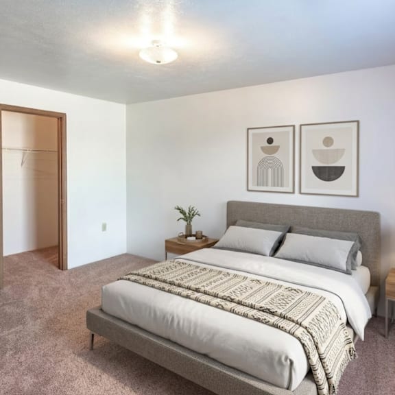 a bedroom with a bed, nightstand, and two framed pictures on the wall.