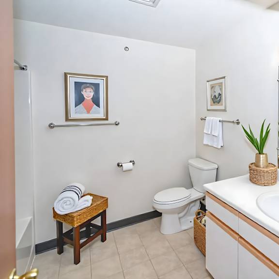 a bathroom with a white sink, toilet, and a mirror.