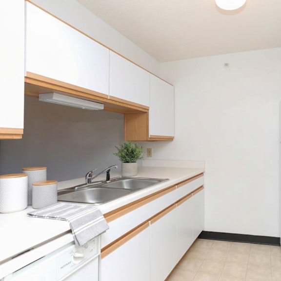 a kitchen with white cabinets and a white fridge.