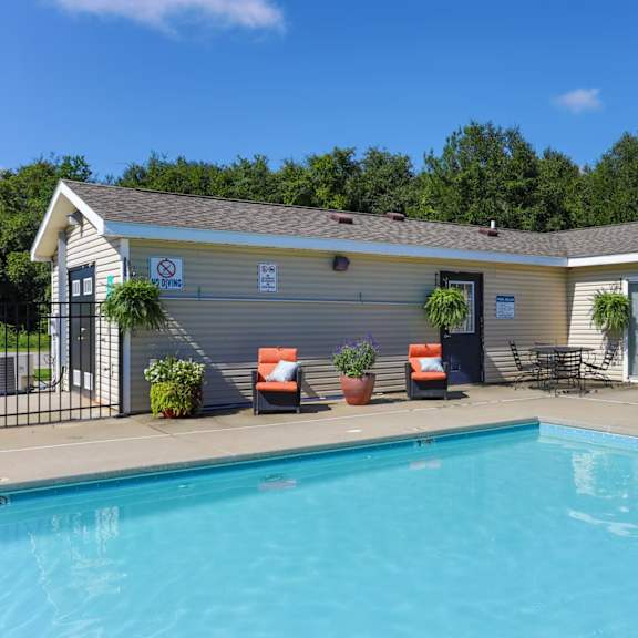 a pool in front of a small building with a sign on it.