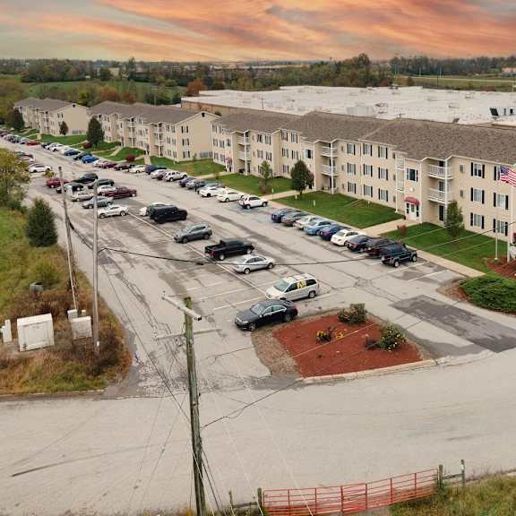 a parking lot with cars and a building in the background.