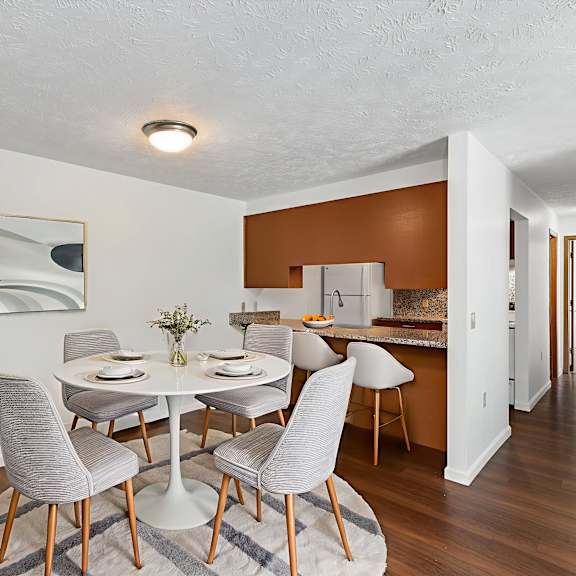a dining room with a white table and grey chairs.