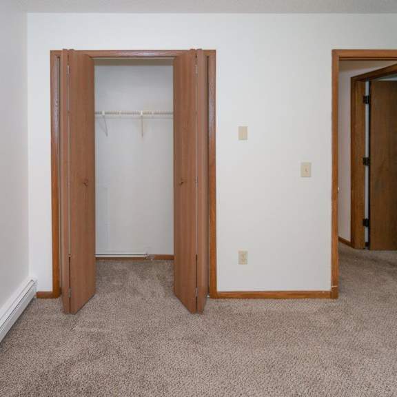 a bedroom with a closet and a door to a bathroom