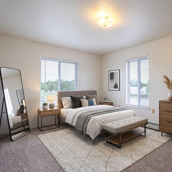 a bedroom with a large bed, a chair, and a dresser.