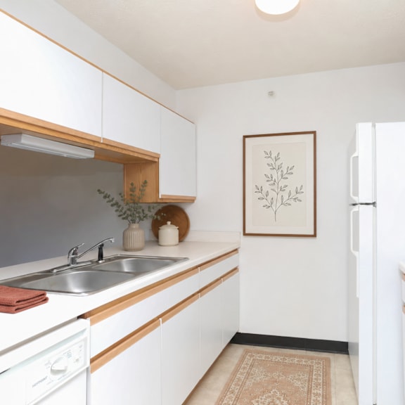a kitchen with white cabinets and a fridge.