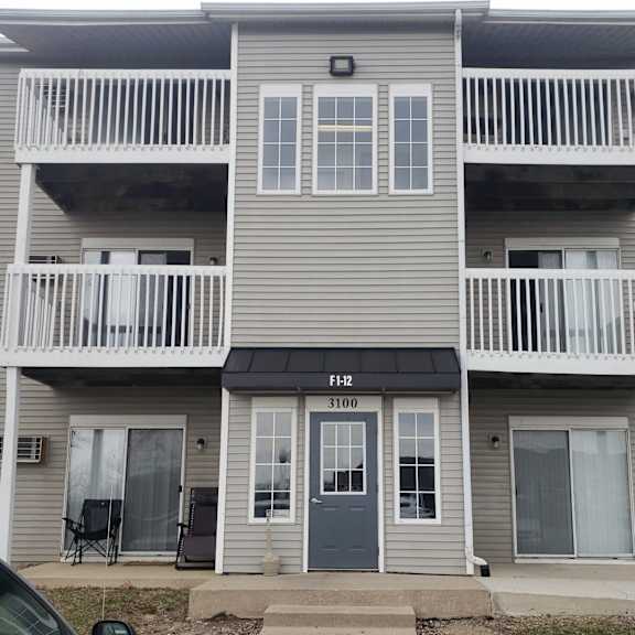 a two-story apartment building with a balcony on each floor.