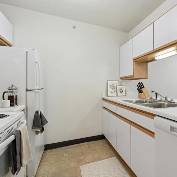 a kitchen with white appliances and wooden cabinets.