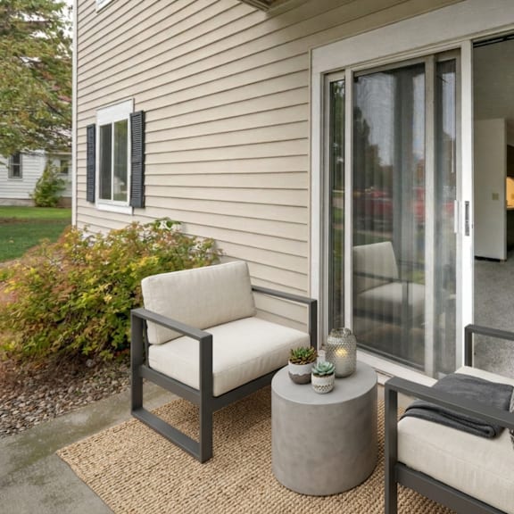 a patio with a chair and a table with candles on it.