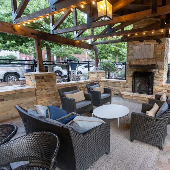 a patio with chairs and a fireplace and a tv
