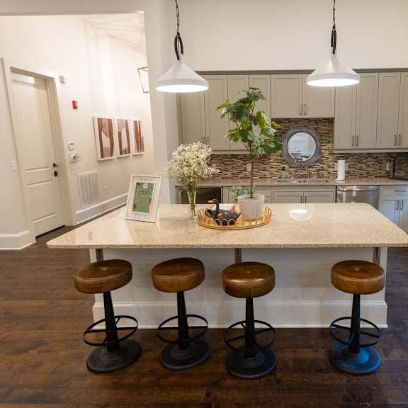 woodstock west by walton community room coffee station  a kitchen with a large island with four stools