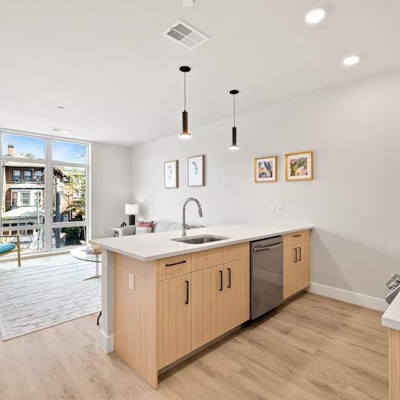 an open kitchen and living room with a sliding glass door to a patio
