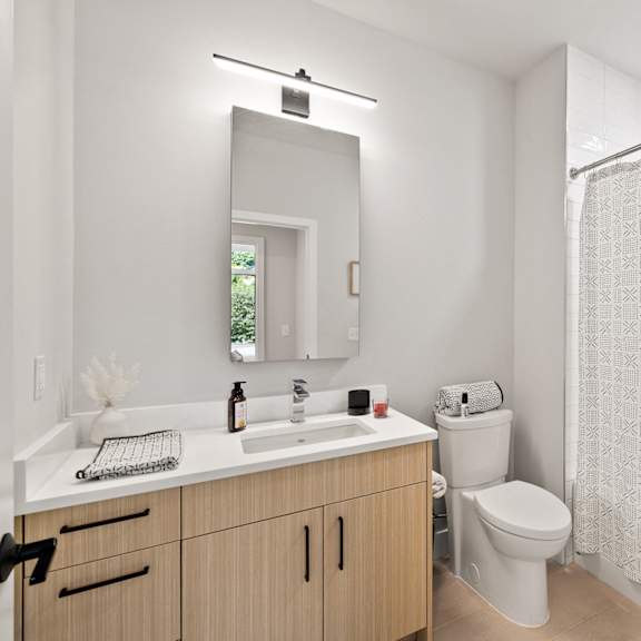 a bathroom with a shower toilet and sink and a mirror