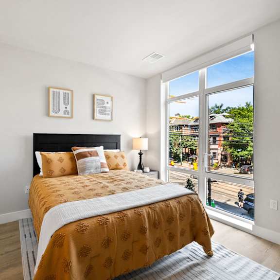 a bedroom with a bed and a large window