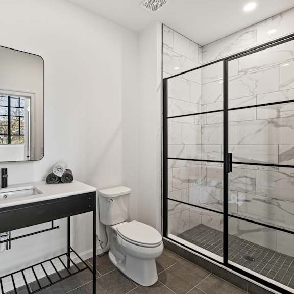 a bathroom with a shower toilet and sink and a mirror