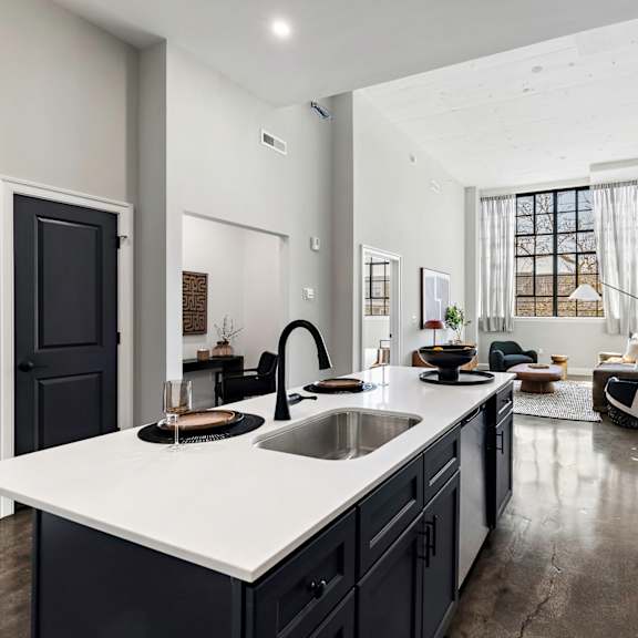 a kitchen with a large white counter top and a sink