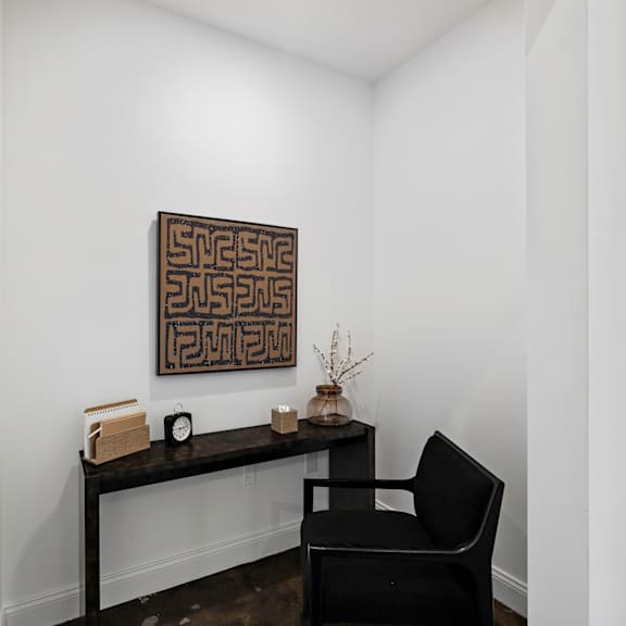 room with a desk and a chair and a painting on the wall