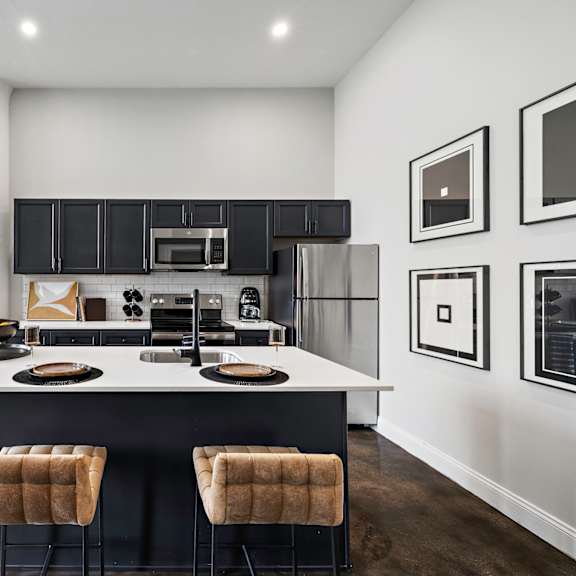 a kitchen with black cabinets and a white counter top