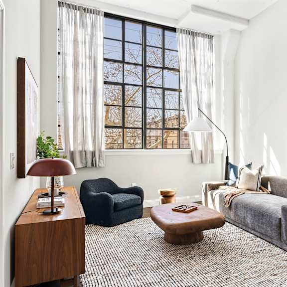 a living room with a couch and a chair and a window