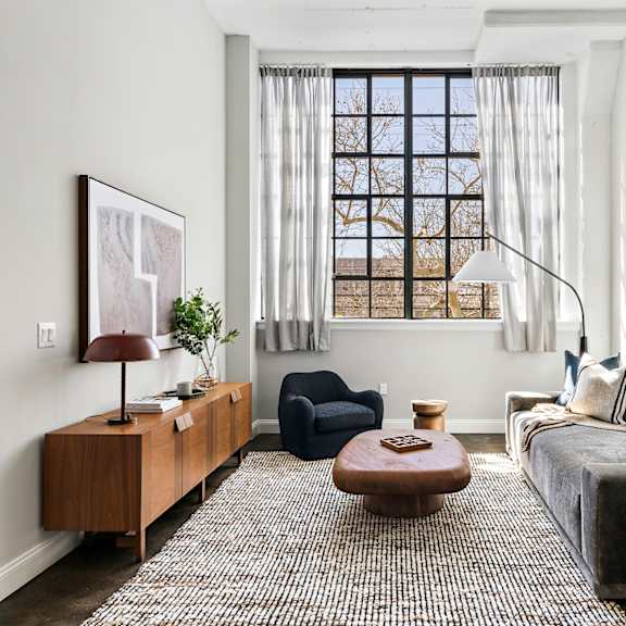 a living room with a gray couch and a window