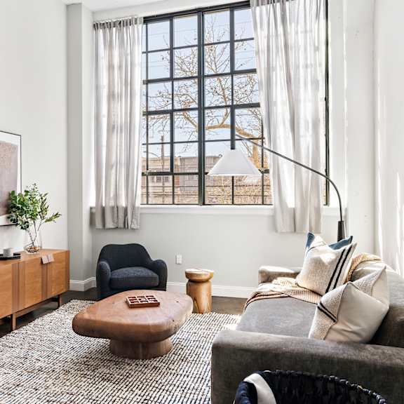 a living room with a couch and a chair and a window