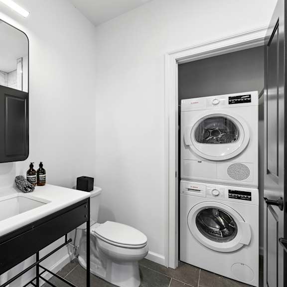 a bathroom with a toilet sink and a washing machine