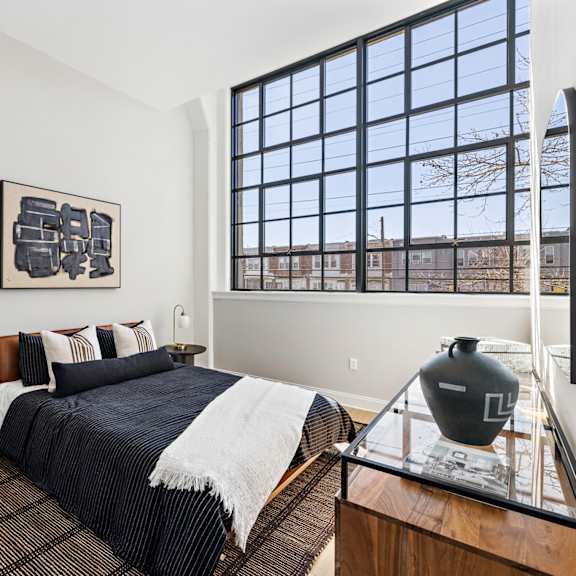 a bedroom with a bed and a large window