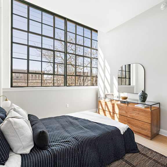 a bedroom with a bed and a large window