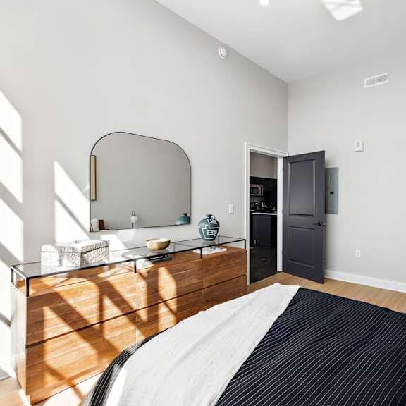 a bedroom with a bed and a dresser with a mirror