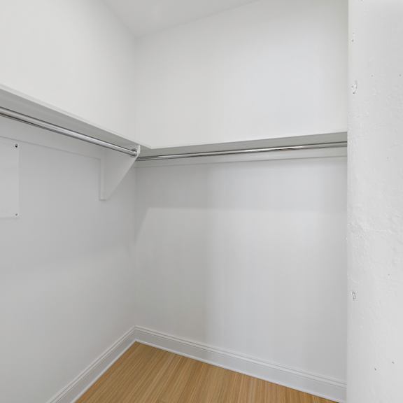 the living room of an empty apartment with white walls and a wood floor