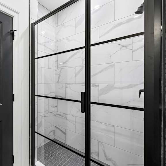 a black and white photo of a glass door with a reflection of a window