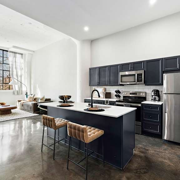 a kitchen with a center island and a stainless steel refrigerator