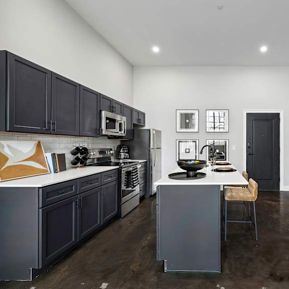 a kitchen with black cabinets and a white counter