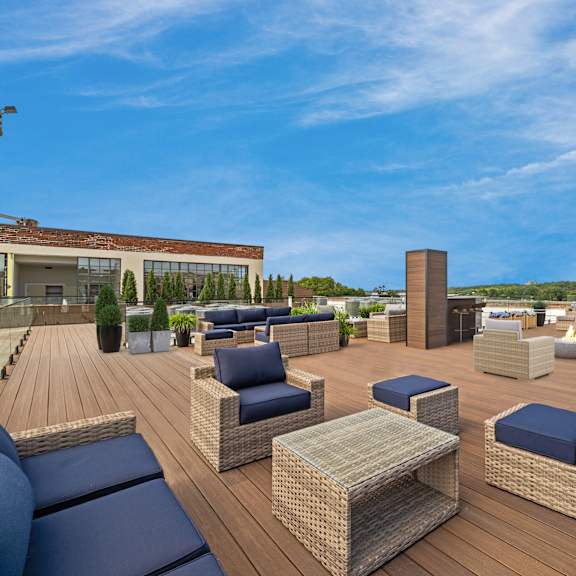 a roof top patio with furniture and a blue sky