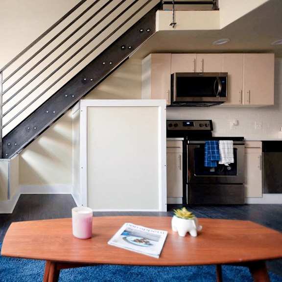 a living room with a couch a table and a staircase