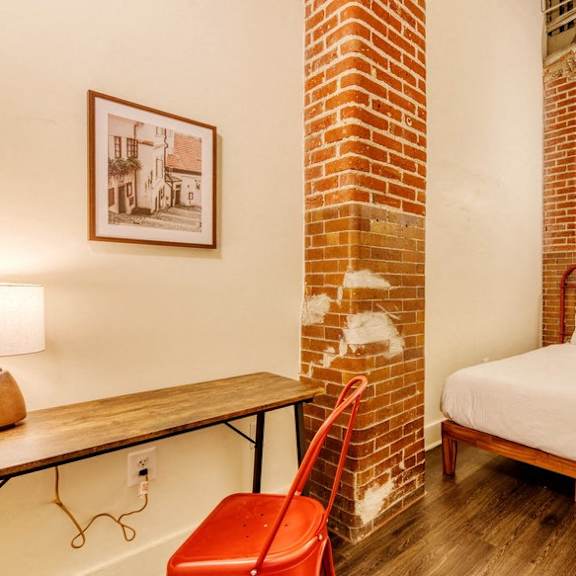 a bedroom with a bed and a desk and a chair