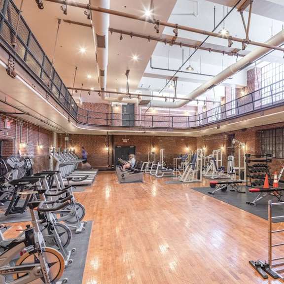the gym atrium has a lot of exercise bikes and other fitness equipment