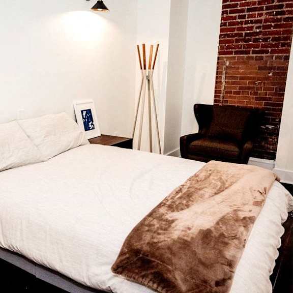 a bedroom with a bed and a brick wall