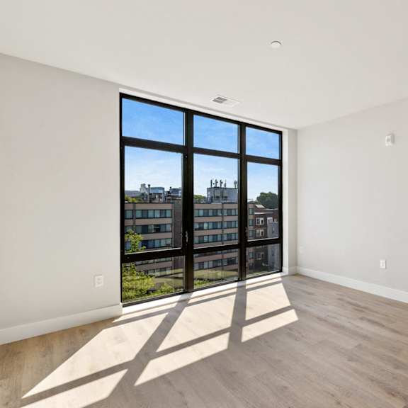 a living room with a large window and wooden floors