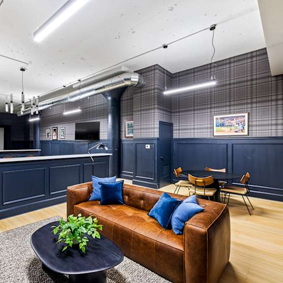 a living room with a leather couch and a kitchen