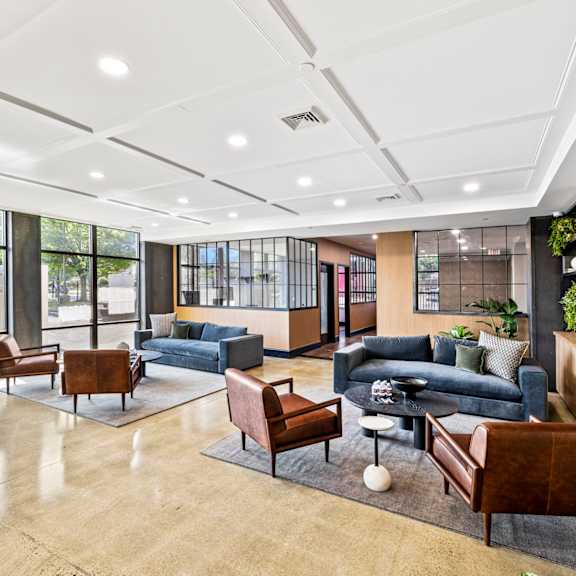 a lobby with couches and chairs and a tv