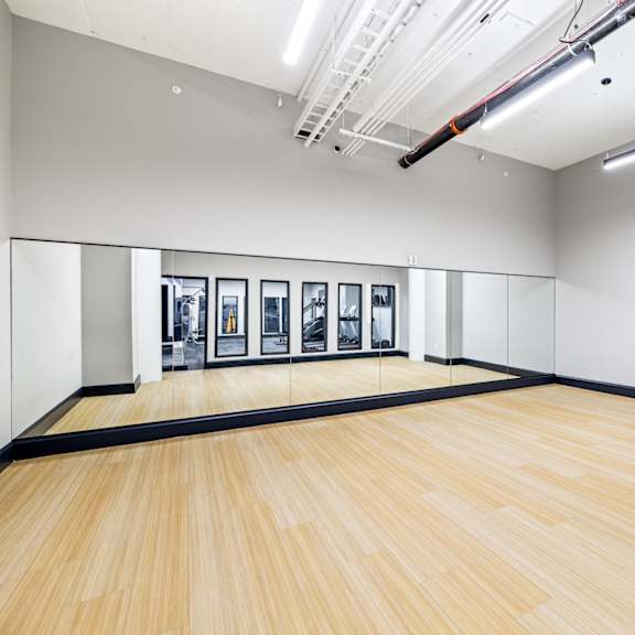 a large room with a wooden floor and paintings on the wall