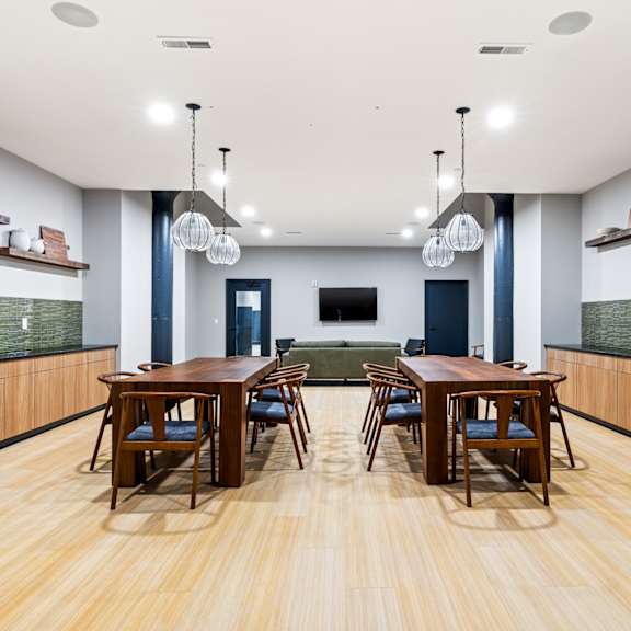 a dining room with wooden tables and chairs and a green couch