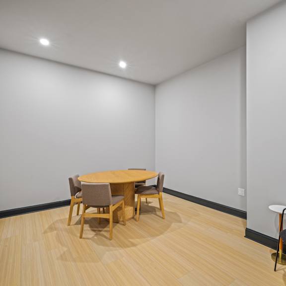 a dining room with white walls and a wooden table and chairs
