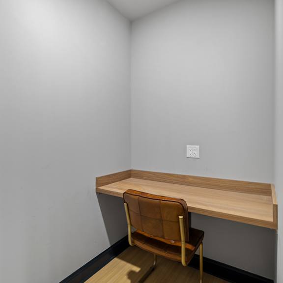 a desk and a chair in a room with white walls