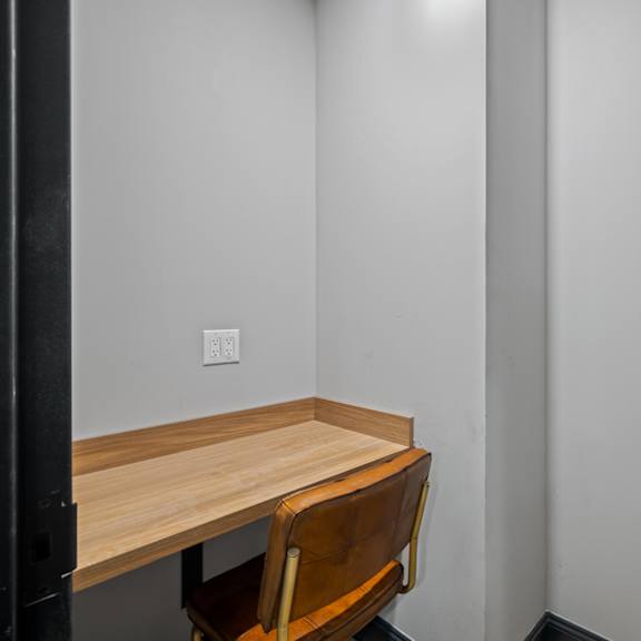a small desk in a room with a chair