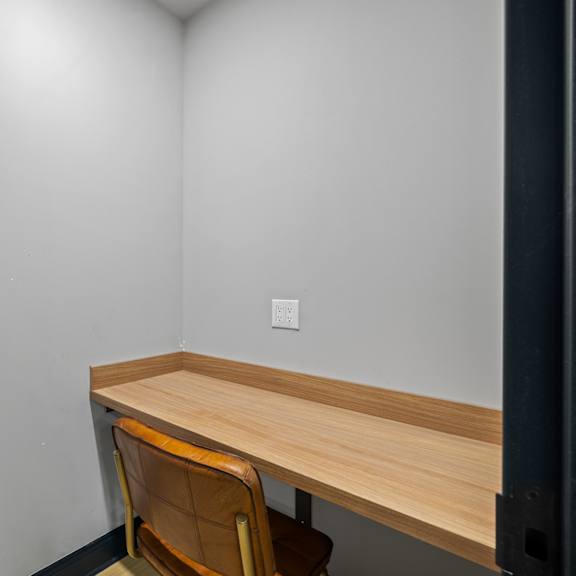 a desk and chair in a room with white walls